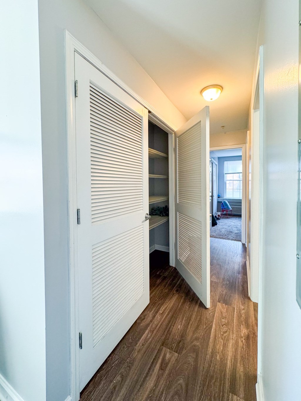 a hallway with a closet and a door to a bedroom